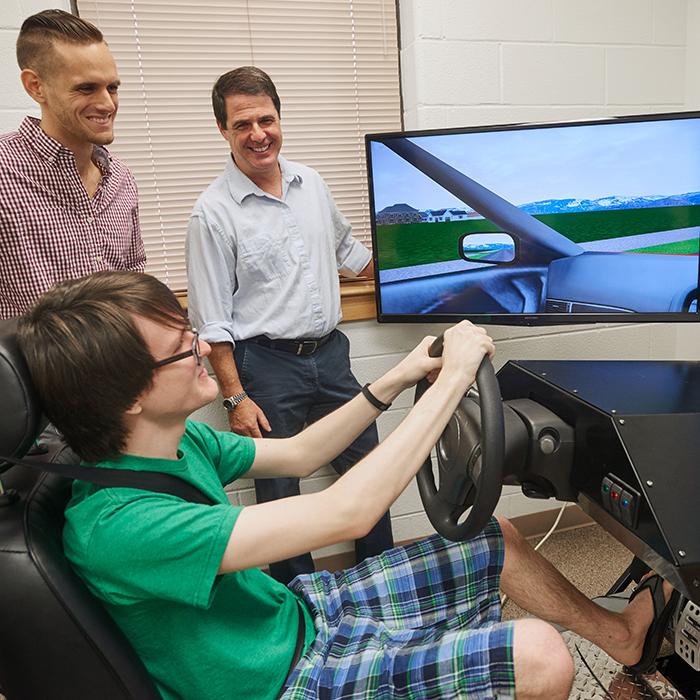心理学学生作为研究生在驾驶模拟器中旋转，教授记录结果.
